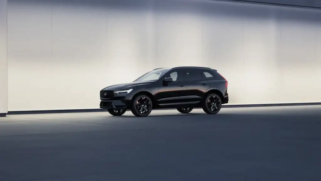 2026 Volvo XC60 in black with sport alloy wheels shown in side profile against a minimalist studio backdrop, representing fuel efficiency near Johnson City TN