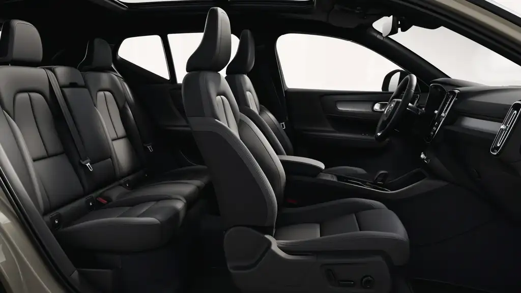 2026 Volvo EX40 interior showing full black leather front and rear seating with open panoramic roof and vertical infotainment screen near Asheville NC