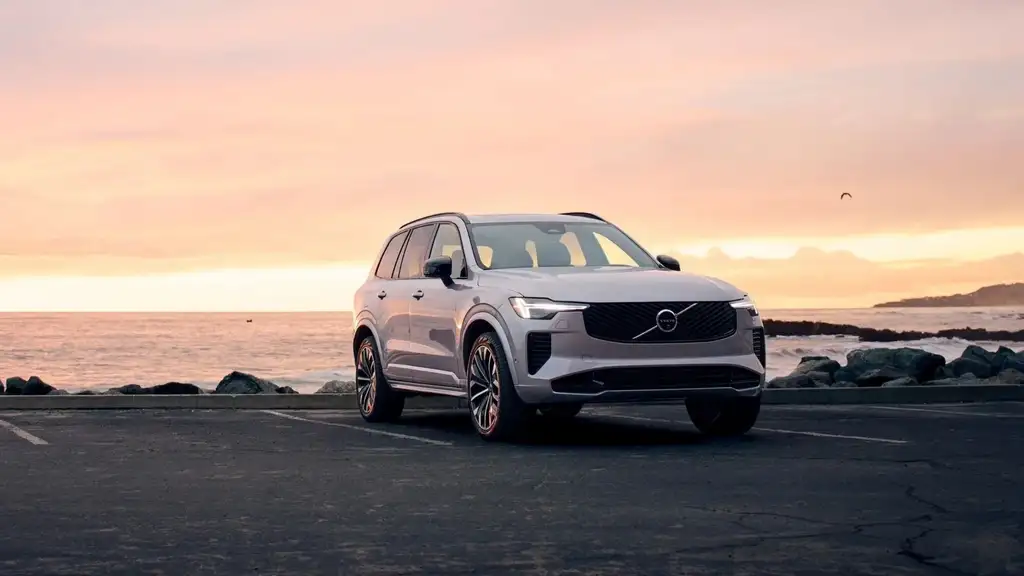 2026 Volvo XC90 plug-in hybrid luxury SUV in silver parked at coastal overlook during golden hour sunset near Asheville NC