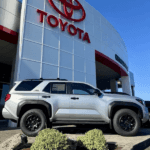 An SUV parked in front of a Toyota dealership