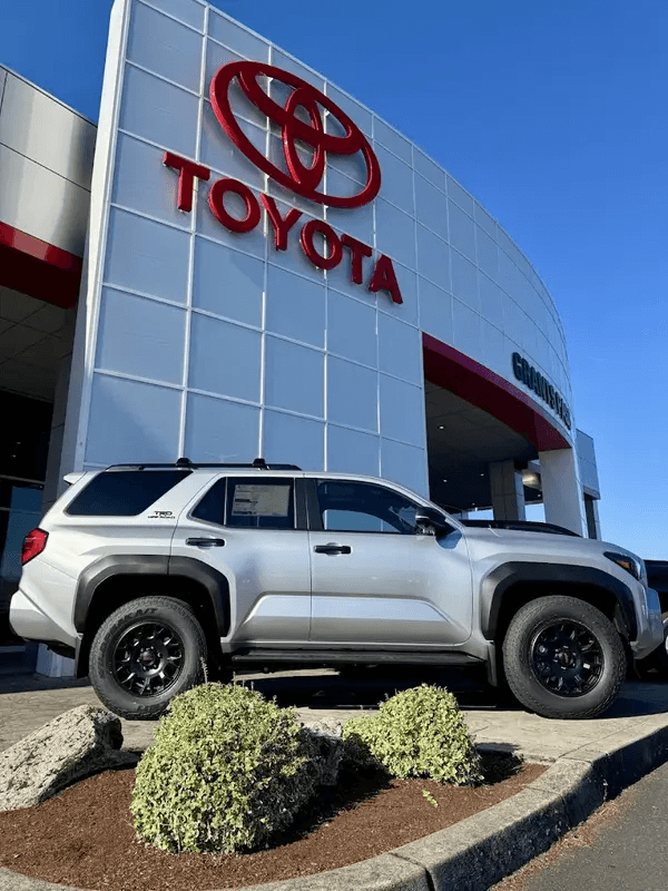 An SUV parked in front of a Toyota dealership