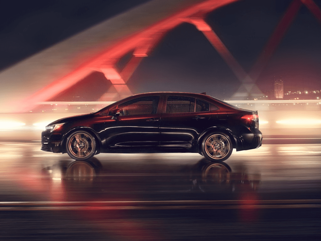 A pre-owned Toyota sedan on the road at night