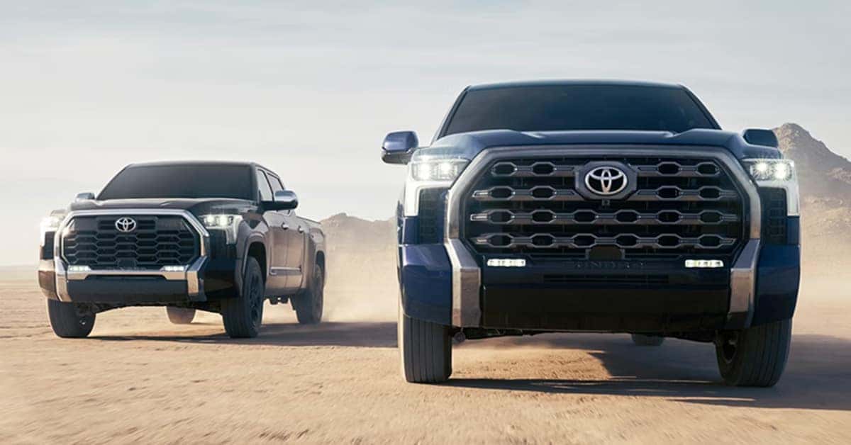 two 2026 Toyota Tundra driving side-by-side in a desert