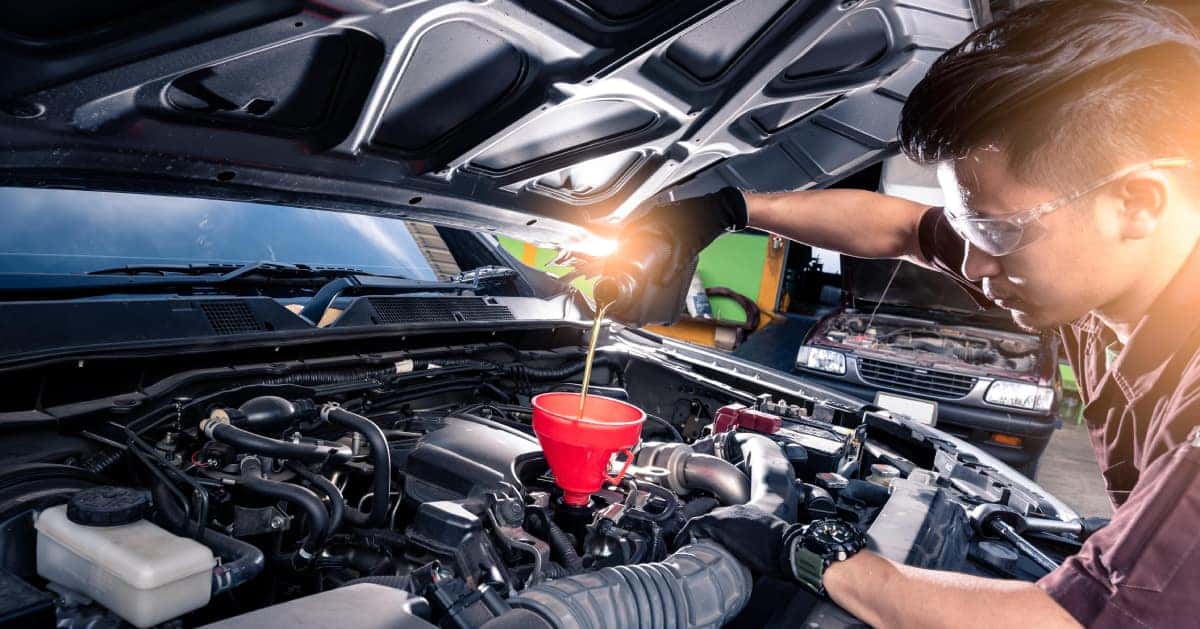 a mechanic changing the oil in a car