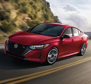 A front facing red Nissan car