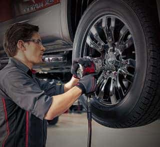 A service technician beside a Nissan car