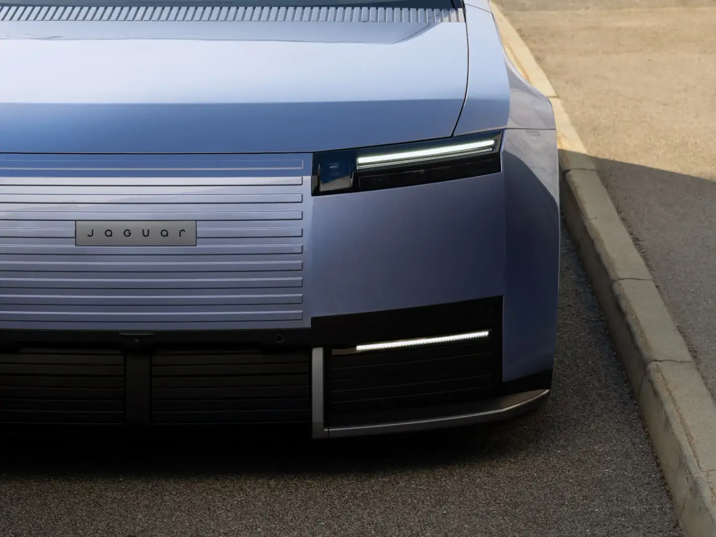 Close-up of Jaguar Type 01 front end with horizontal grille lines, Jaguar badge and slim LED headlight