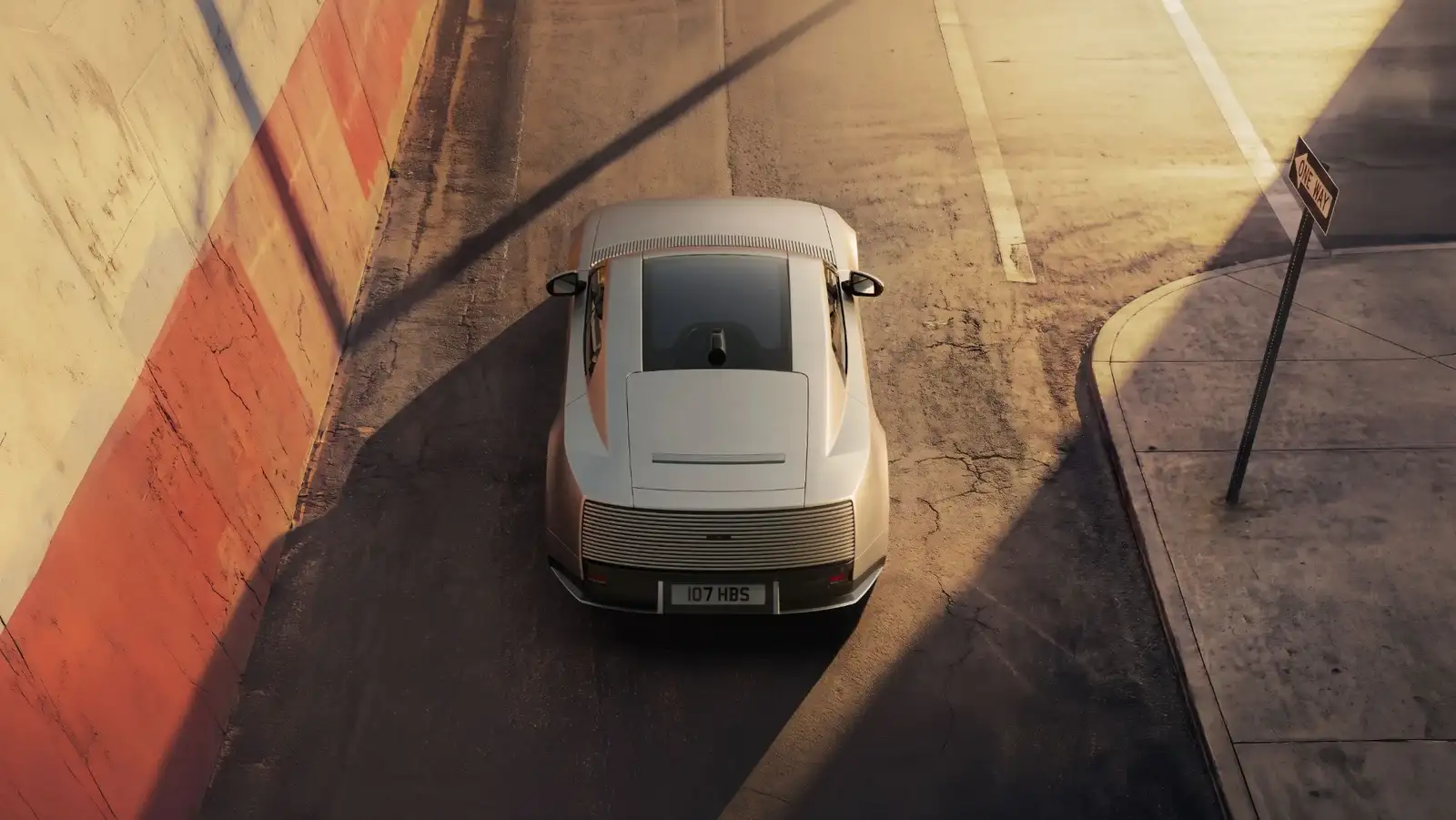 Overhead rear view of a silver Jaguar Type 01 on a sunlit street