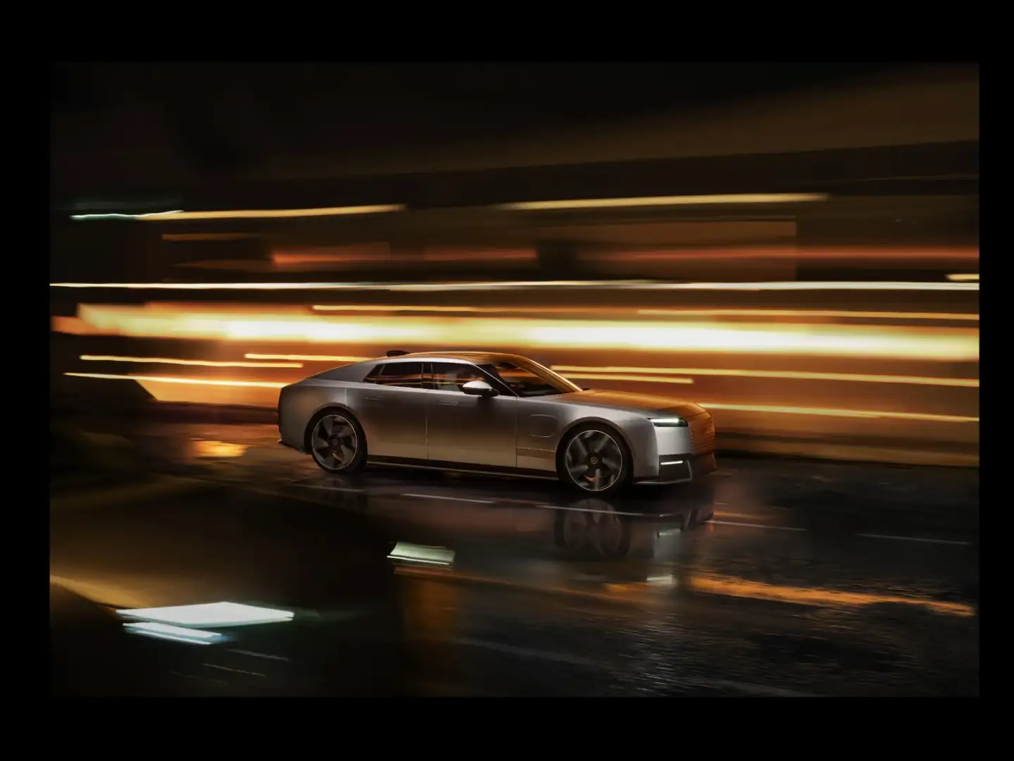 Silver Jaguar Type 01 in motion at night with orange light streaks