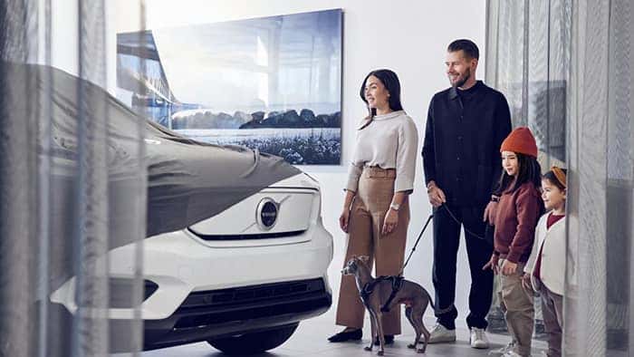 A family standing next to their new Volvo