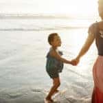 Shot of a young woman spending time at the beach with her daughter