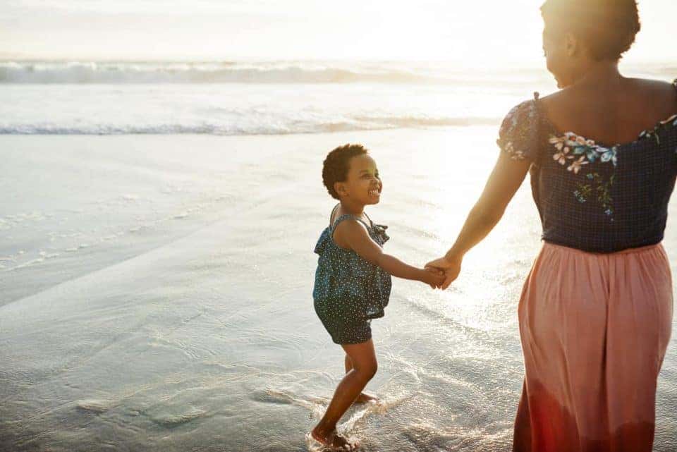 Shot of a young woman spending time at the beach with her daughter