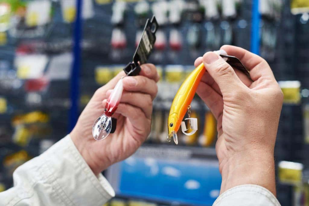 Fishing lure baits in the hands of man in the store