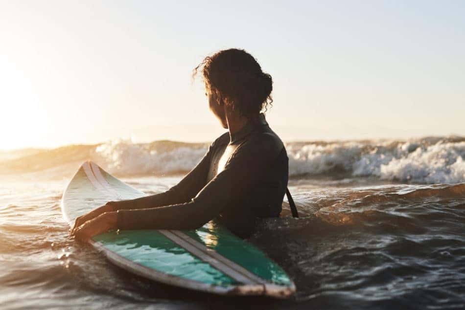 Shot of a young woman surfing in the ocean