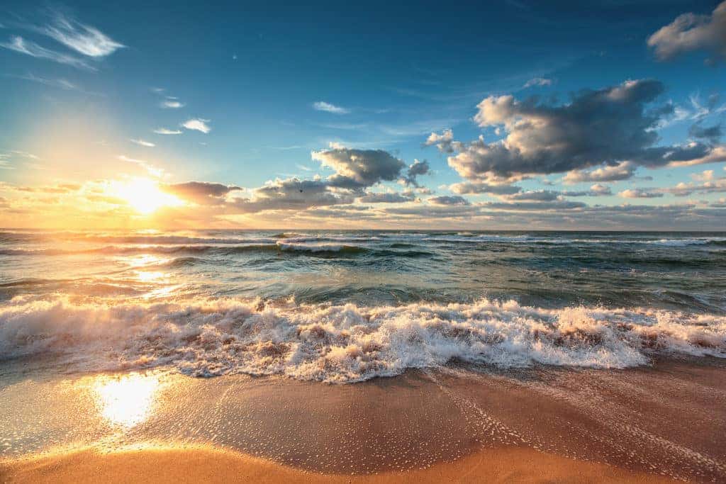 horizon shot of water crashing onto beach