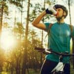 Handsome young professional cyclist dressed in cycling clothing and protective helmet