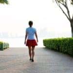 Woman walking on brick footpath.
