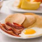 Breakfast plate with pancakes, eggs, bacon and fruit.