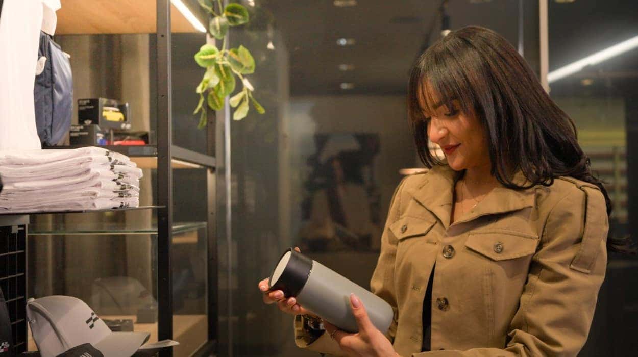 Shopper looking at water bottle in boutique
