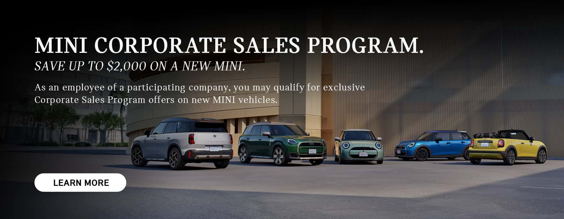 MINI Models in a line parked in front of a building.