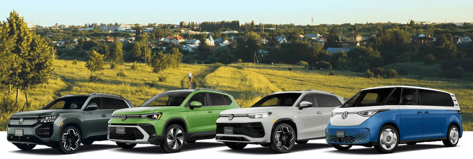 Volkswagen lineup featuring the Atlas, Taos, Tiguan, and ID.Buzz displayed in front of a green countryside