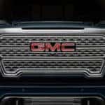 2019 GMC Sierra 1500 Denali in black parked showing the grill and LED headlights.