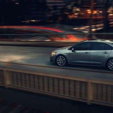 Toyota_Corolla_Driving_In_City_On_Bridge