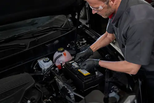 A shot of a service technician's hand, doing an oil change.