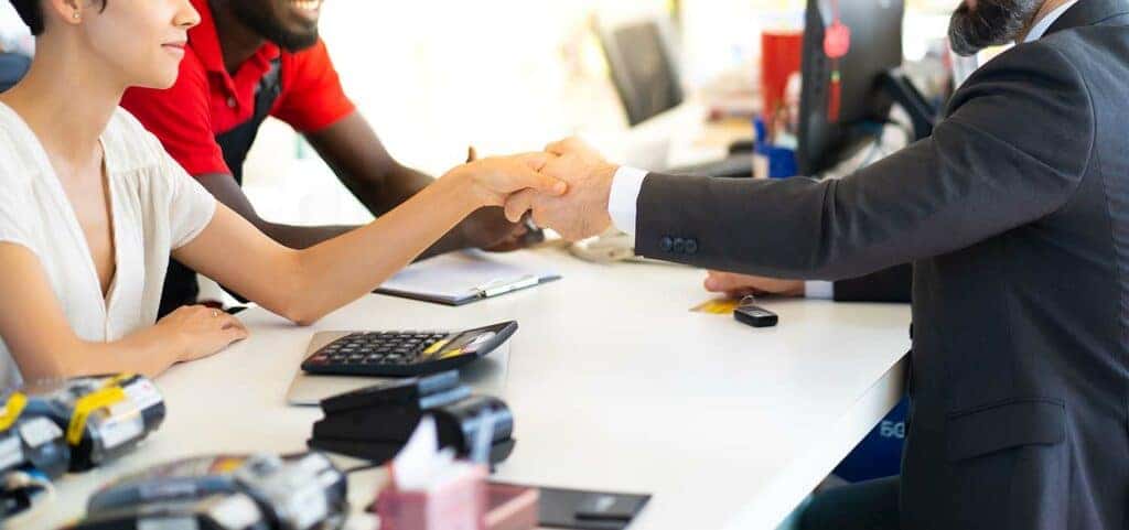 Defining APR at Stetler DCJR in York, PA | Customer and sales person shaking hands on a car deal at a desk