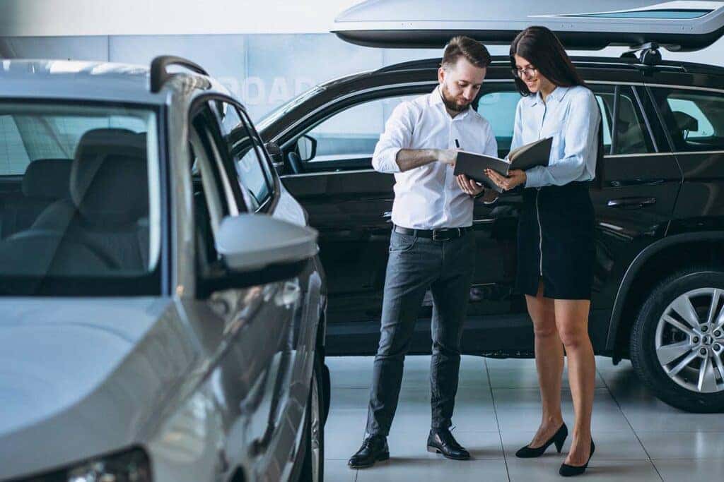 Defining APR at Stetler DCJR in York, PA | Sales person showing a customer the APR on avaible cars on the lot