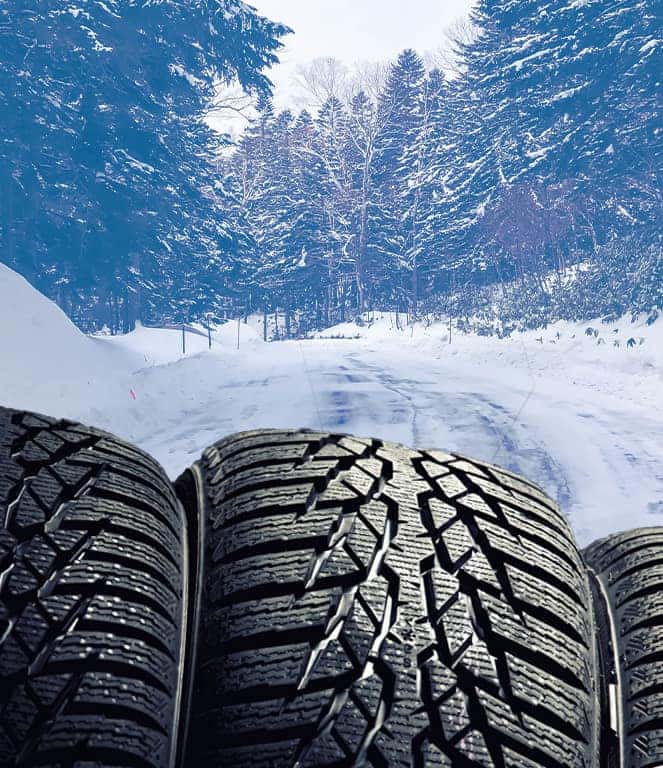 The Cold Facts of Winter Tires | Stetler DCJR in York, PA | Close up of winter tires with the background of a road covered in snow