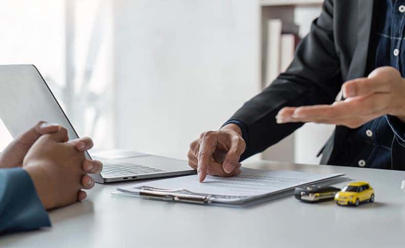 The Advantages of Buying a Car from a Dealership vs. a Private Seller. Learn more at Stetler DCJR in York, PA | Man in suit showing the paperwork for a new car