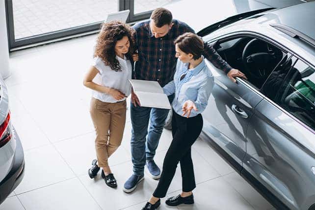 When to Trade In Your Car | Stetler DCJR in York, PA | Sales woman showing the paperwork for trading in a car at the dealership