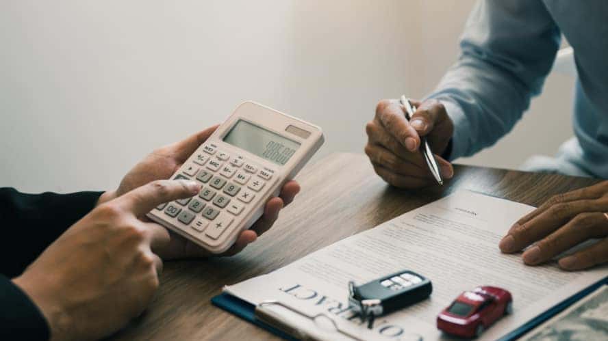 A finance expert helping someone go over their auto loan contract.