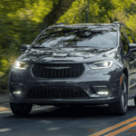 A gray Chrysler Pacifica driving down the road.