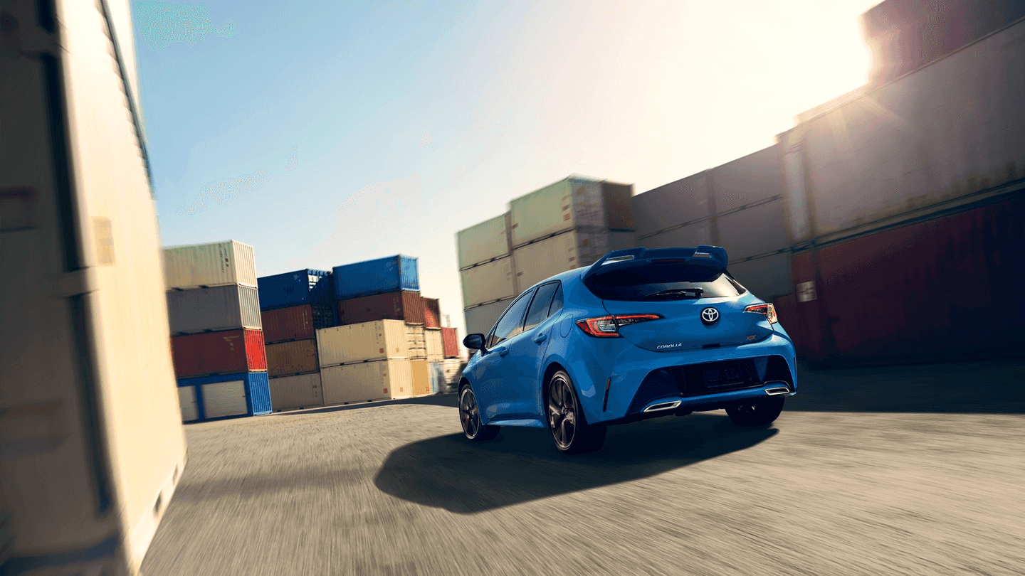 Toyota_Corolla_Hatchback_Blue_Driving_Rear_View
