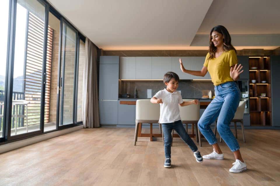 Happy mother and child dancing while they stay cool inside.
