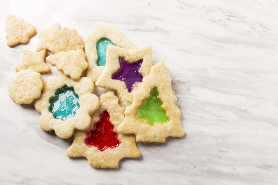 A collection of stained glass Christmas cookies on marble