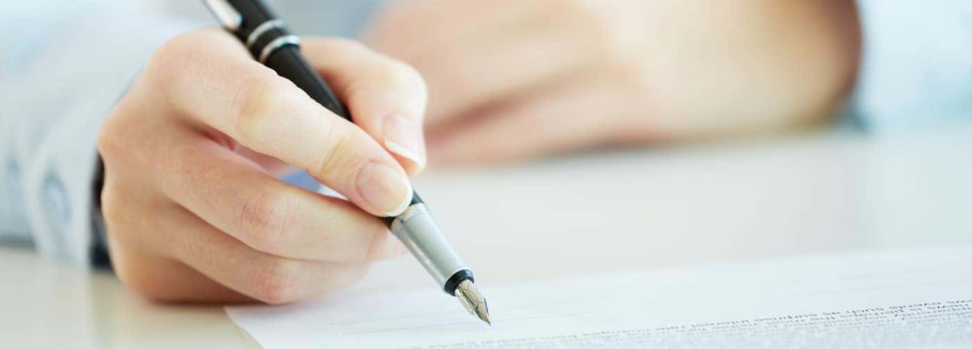 Mans Hand Reviewing a Liability Insurance Agreement