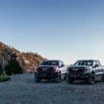 Front three-quarter views of the 2023 GMC Sierra 1500 AT4X AEV Edition (right) and the new 2023 GMC Sierra 1500 AT4X (left) parked off-road. Later in the 2023 model year, a new Sierra 1500 AT4X will be available with AEV-inspired enhancements, including a stamped steel winch-capable front bumper, boron steel front approach skid plate and 33-inch Goodyear Wrangler Territory MT tires.