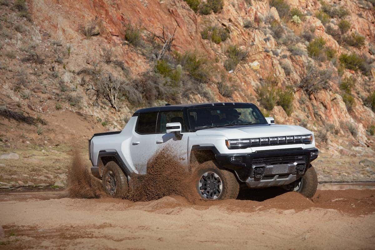 Front 7/8 view of the 2023 GMC HUMMER EV Edition 1 Pickup kicking up dirt. The 2023 GMC HUMMER EV Edition 1 Pickup boasts independent front and rear suspension systems paired to the drive motors, which are optimized for handling in all conditions.
