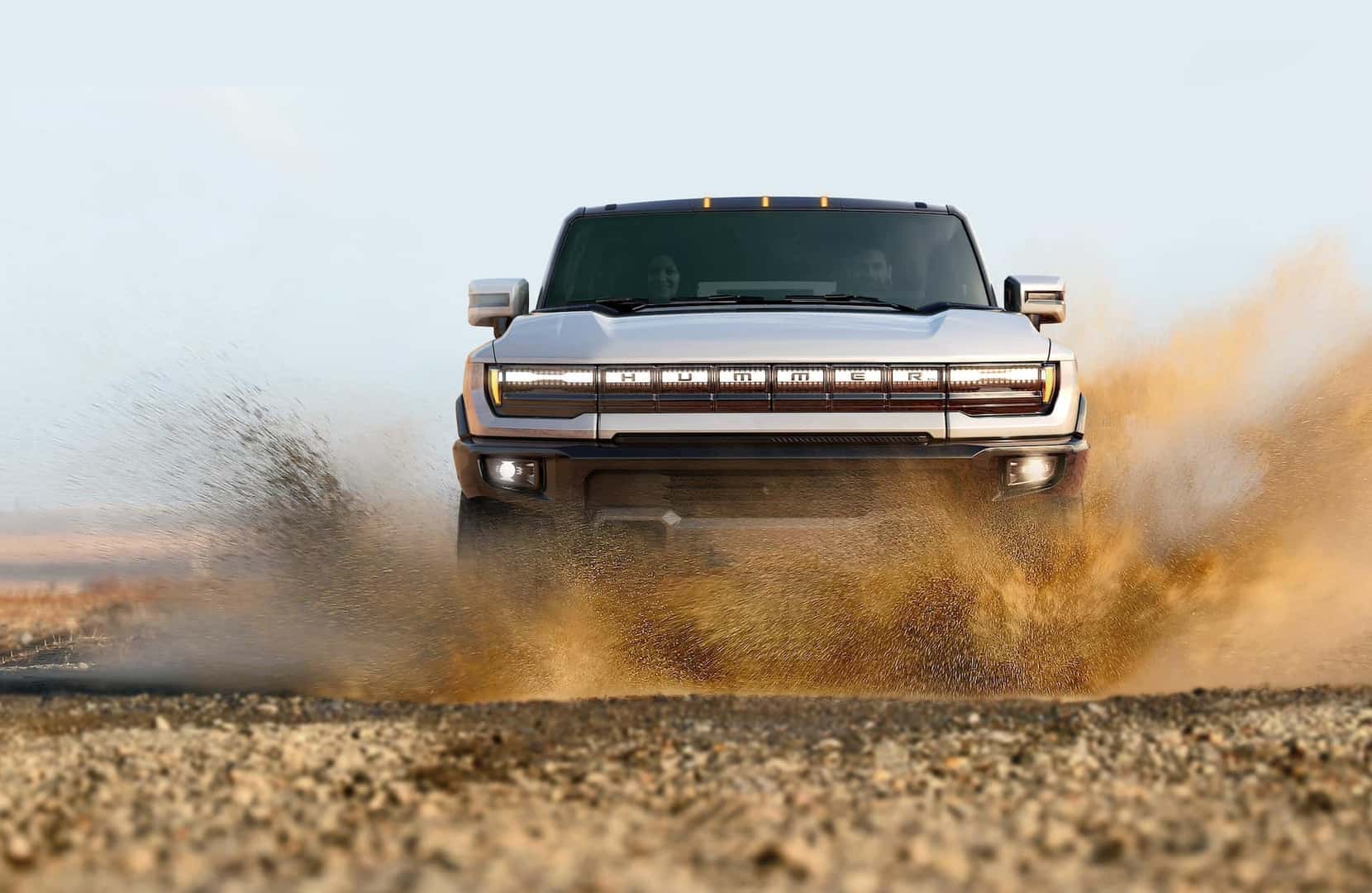 2024 GMC Hummer EV SUV driving through mud