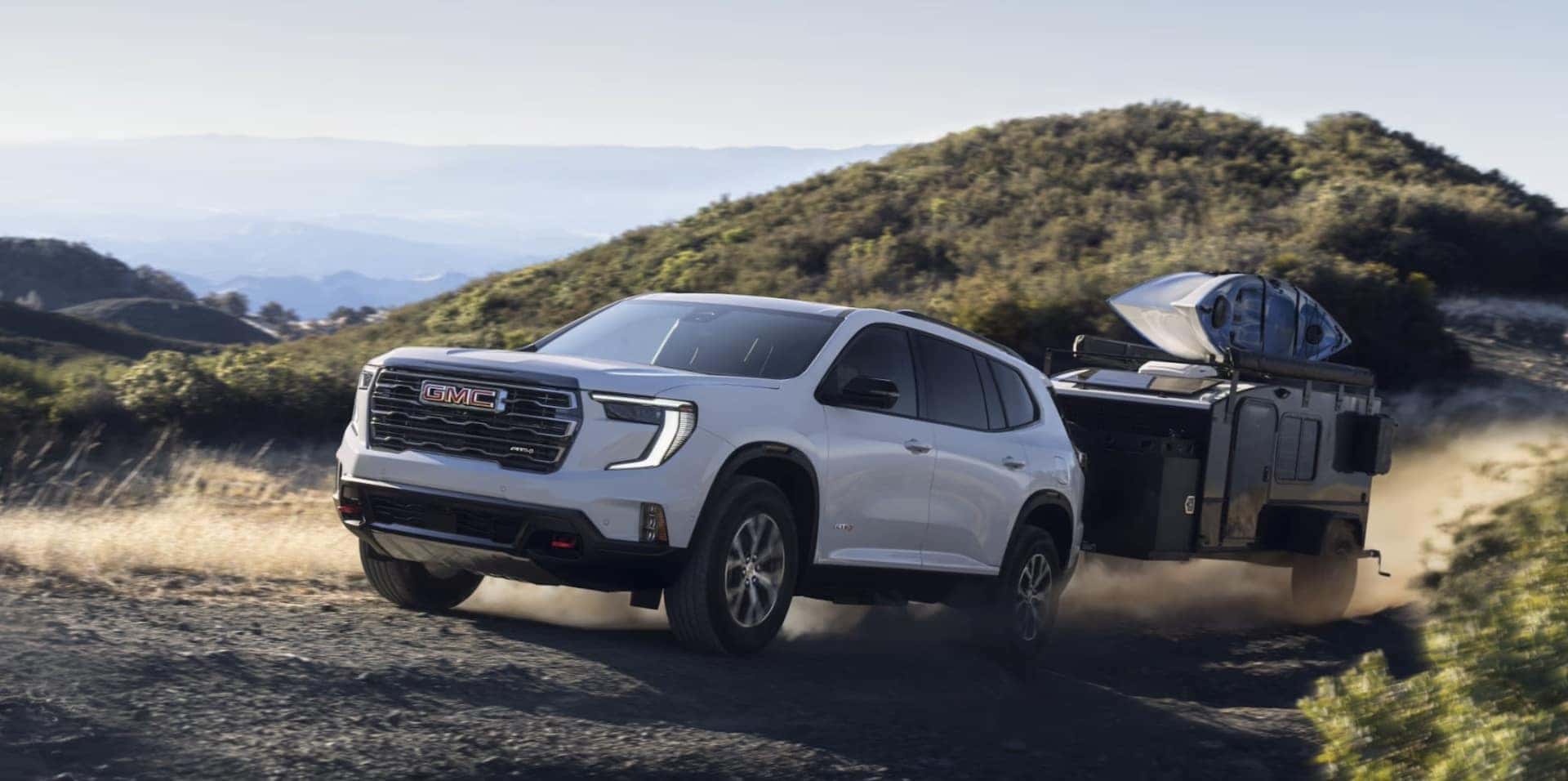2024 GMC Acadia towing a camper with kayaks