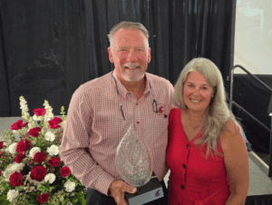 Ron and LoriAnne Claudon pose holding the Cougar Spirit Award
