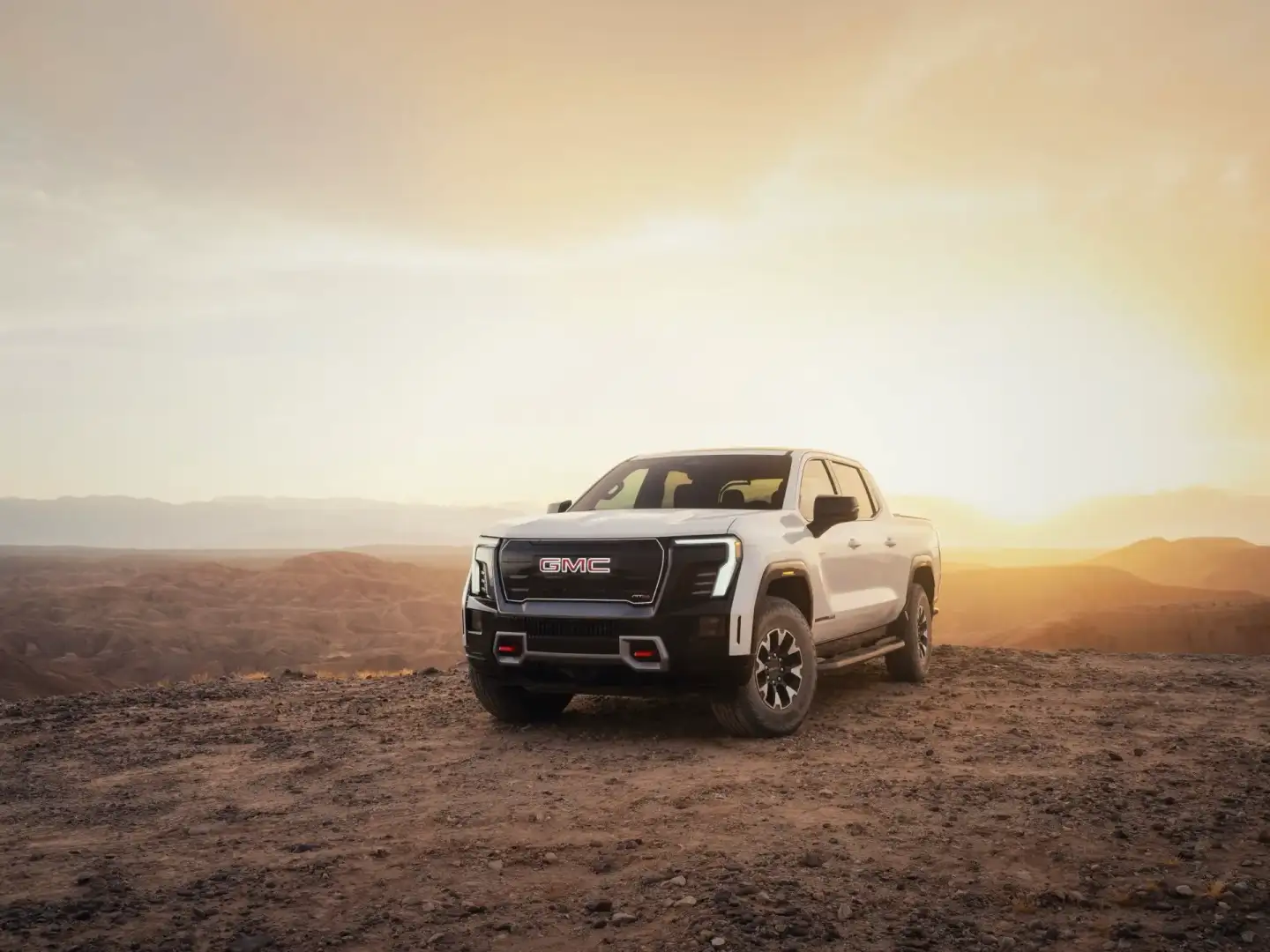 White 2026 GMC Sierra EV parked off road in the desert