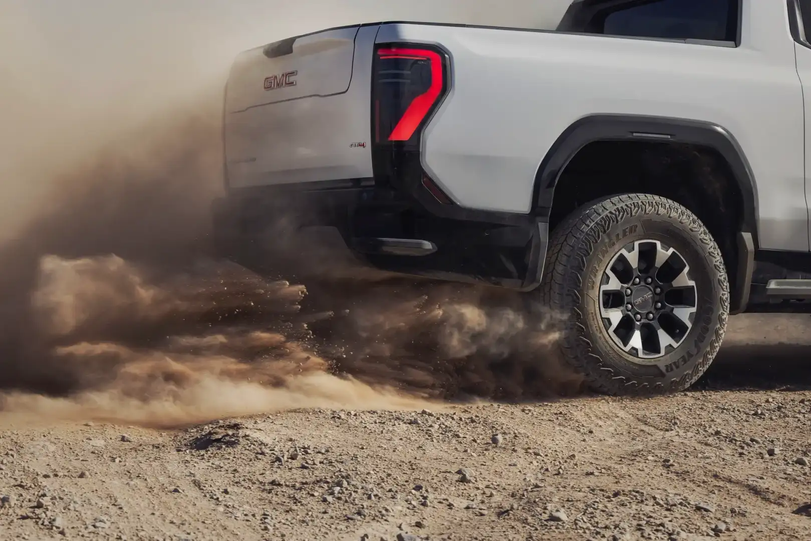 Rear View of a White GMC Sierra EV AT4 off roading int he desert