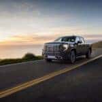 The Luxurious GMC Sierra Denali Driving On The Edge Of Cliff As The Sun Rises Above The Clouds