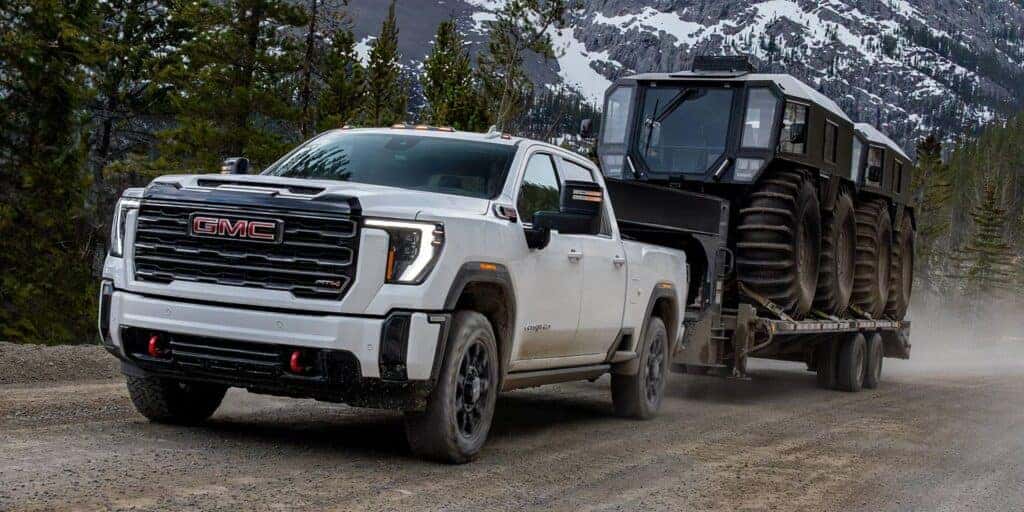 The Powerful And Strong 2026 GMC Sierra HD Towing A Long Trailer Of Machinery Vehicles With Ease