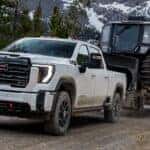 The Powerful And Strong 2026 GMC Sierra HD Towing A Long Trailer Of Machinery Vehicles With Ease