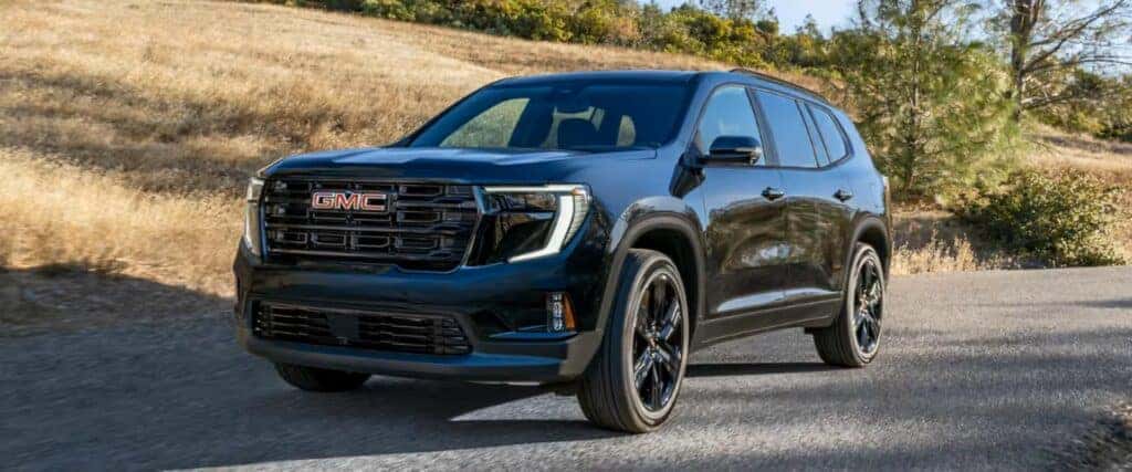 The Family-Friendly And Stylish 2026 GMC Acadia, Driving Past A Golden Hill